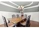 Hardwood floor dining room with tray ceiling, chandelier, and space for a large table at 5245 Wilshire Xing, Cumming, GA 30040