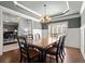 Formal dining room with wainscoting, tray ceiling, chandelier, and hardwood floors at 5245 Wilshire Xing, Cumming, GA 30040