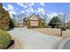 Spacious driveway leading to a beautiful two-story home with a brick exterior and meticulously maintained landscaping at 5245 Wilshire Xing, Cumming, GA 30040