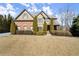 Beautiful two-story home featuring a well-manicured lawn, mature trees, and a brick exterior, exuding curb appeal at 5245 Wilshire Xing, Cumming, GA 30040