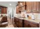 Close up of a kitchen with dark wood cabinets and granite countertops, featuring a cooktop at 5245 Wilshire Xing, Cumming, GA 30040