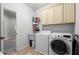 Functional laundry room with washer, dryer, utility sink, and built-in storage cabinets at 5245 Wilshire Xing, Cumming, GA 30040