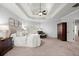 Beautiful main bedroom features neutral tones, tray ceiling, ceiling fan, and access to ensuite at 5245 Wilshire Xing, Cumming, GA 30040