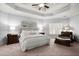 A main bedroom with a tray ceiling, carpet flooring, a seating area, and lots of sunlight at 5245 Wilshire Xing, Cumming, GA 30040