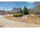 Charming home featuring a landscaped yard, gray siding, a two-car garage, and brick walkway leading to a cozy bench at 110 Centennial Ridge Dr, Acworth, GA 30102