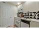 A kitchen is equipped with white cabinets, black and white diamond backsplash, and a stainless-steel sink at 2318 Edgemere Lake Cir, Marietta, GA 30062