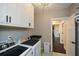 Bright laundry room with front load washer and dryer, white cabinets, and access to other rooms at 29 Macedonia Rd, White, GA 30184