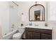 Traditional bathroom featuring a white tile shower-tub, with a wood framed mirror and vanity at 144 Murray Hill Ne Ave, Atlanta, GA 30317