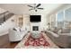 Open living room with a fireplace, built-in shelving, a ceiling fan, and large windows for natural light at 2435 Portsmouth Ct, Marietta, GA 30064