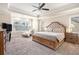 Spacious main bedroom featuring tray ceilings, a ceiling fan, plush carpet and an abundance of natural light at 2435 Portsmouth Ct, Marietta, GA 30064