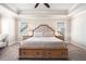 Neutral-colored carpeted main bedroom featuring tray ceilings, night stands, and a tufted headboard at 2435 Portsmouth Ct, Marietta, GA 30064