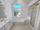 Bright bathroom featuring a soaking tub with a garden view and a glass-enclosed shower at 2925 Chesterfield Se Way, Conyers, GA 30013