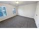 Bedroom featuring gray carpet, neutral walls, two windows, and white door at 2925 Chesterfield Se Way, Conyers, GA 30013