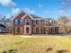 Charming brick home with a manicured lawn, black shutters, and an arched window above the front door at 2925 Chesterfield Se Way, Conyers, GA 30013