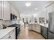 Bright kitchen featuring stainless steel appliances, white cabinets, and hardwood floors at 724 Eastwood Rise, Stone Mountain, GA 30087