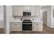 Kitchen featuring stainless steel appliances, light cabinets, and white countertops at 724 Eastwood Rise, Stone Mountain, GA 30087