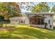 Home's backyard features a well manicured lawn, mature trees, and screen porch at 870 Richmond Hill Dr, Marietta, GA 30068