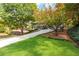 Well-manicured front yard of a beautiful home with mature trees and lush green grass at 870 Richmond Hill Dr, Marietta, GA 30068