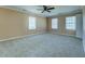 Neutral bedroom with carpet, ceiling fan, three large windows, and plenty of natural light at 1103 Wallington Nw Ct, Conyers, GA 30012
