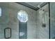 A marble-look tile shower features a window, a shower head and a hand wand at 1103 Wallington Nw Ct, Conyers, GA 30012