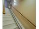 Stair lift on carpeted stairs with wooden handrail offering safety and convenience at 1103 Wallington Nw Ct, Conyers, GA 30012