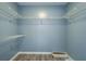 Walk-in closet with shelving and laminate floors at 1103 Wallington Nw Ct, Conyers, GA 30012