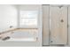 Bathroom featuring soaking tub, window, and shower at 113 Plumeria St, Canton, GA 30114
