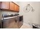 Laundry room with front loading washer/dryer, upper cabinets, and tile flooring at 617 Oakbourne Way, Woodstock, GA 30188