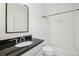 Bathroom with a sleek black countertop vanity, a tub and a shower with white tile at 970 Drewry Ne St, Atlanta, GA 30306