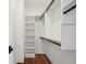 Organized walk-in closet features custom shelving and rod with wood flooring and dark hardware at 970 Drewry Ne St, Atlanta, GA 30306