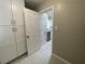 Hallway view leading to a bright kitchen with white cabinets and modern appliances at 1039 Whitfield Se Ct, Smyrna, GA 30080