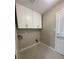 Clean laundry room with white cabinets, light gray walls and tile flooring at 1039 Whitfield Se Ct, Smyrna, GA 30080