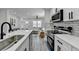 Bright kitchen with stainless steel appliances, black hardware, subway tile backsplash and views into the living room at 2767 3Rd Sw Ave, Atlanta, GA 30315