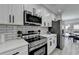 Kitchen showcasing white counters and cabinets, stainless steel appliances, subway tile backsplash, and access to the back deck at 2767 3Rd Sw Ave, Atlanta, GA 30315