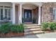 Elegant stone steps lead to a decorative double door framed by white columns and lush shrubbery at 2813 Long Grove Ct, Marietta, GA 30062