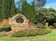 Attractive stone sign for Madison Hall framed by colorful flower beds and mature greenery at 2813 Long Grove Ct, Marietta, GA 30062