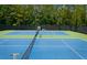 Community tennis courts featuring a clean green and blue surface with a black fence and well-manicured trees at 2813 Long Grove Ct, Marietta, GA 30062