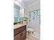 A stylish bathroom featuring a granite countertop vanity, leaf-patterned shower curtain, and coordinated cabinet at 650 New Morn Dr, Hampton, GA 30228