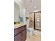 A clean bathroom with a glass door shower, granite countertop vanity, and tiled floors at 650 New Morn Dr, Hampton, GA 30228