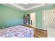 Cozy bedroom with floral bedding, wood floors, and bright green walls at 650 New Morn Dr, Hampton, GA 30228