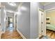 Bright hallway with hardwood floors, blue rugs, white trim, and light blue walls provides access to bedrooms and other areas at 650 New Morn Dr, Hampton, GA 30228