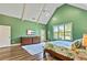 Bright main bedroom featuring vaulted ceilings, wood floors, and backyard views at 650 New Morn Dr, Hampton, GA 30228