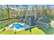 A view of a private backyard oasis with a sparkling pool, spa, and meticulously maintained lawn at 650 New Morn Dr, Hampton, GA 30228