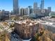 A high-angle, long shot of a beautiful brick building with city views and manicured trees surrounding at 115 W Peachtree Nw Pl # 602, Atlanta, GA 30313