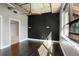 Bright bedroom features hardwood floors, a black accent wall, and a modern industrial ceiling with fan at 115 W Peachtree Nw Pl # 602, Atlanta, GA 30313