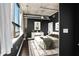 Bedroom with hardwood floors, black accent wall, concrete ceiling, and large bright window at 115 W Peachtree Nw Pl # 602, Atlanta, GA 30313