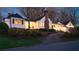 Charming white home with a black roof, landscaped yard and inviting warm light pouring from the windows at 255 Maple Nw Ave, Marietta, GA 30064