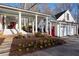 White home featuring a covered porch with columns, outdoor fireplace, and a three-car garage with pergola at 255 Maple Nw Ave, Marietta, GA 30064