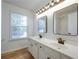 Bright bathroom featuring double sinks and a mirror reflecting the shower at 770 Potters Bar Ln, Suwanee, GA 30024