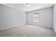 A sunlit bedroom featuring neutral carpet, light gray walls and a window at 3845 Alden Place, Cumming, GA 30028